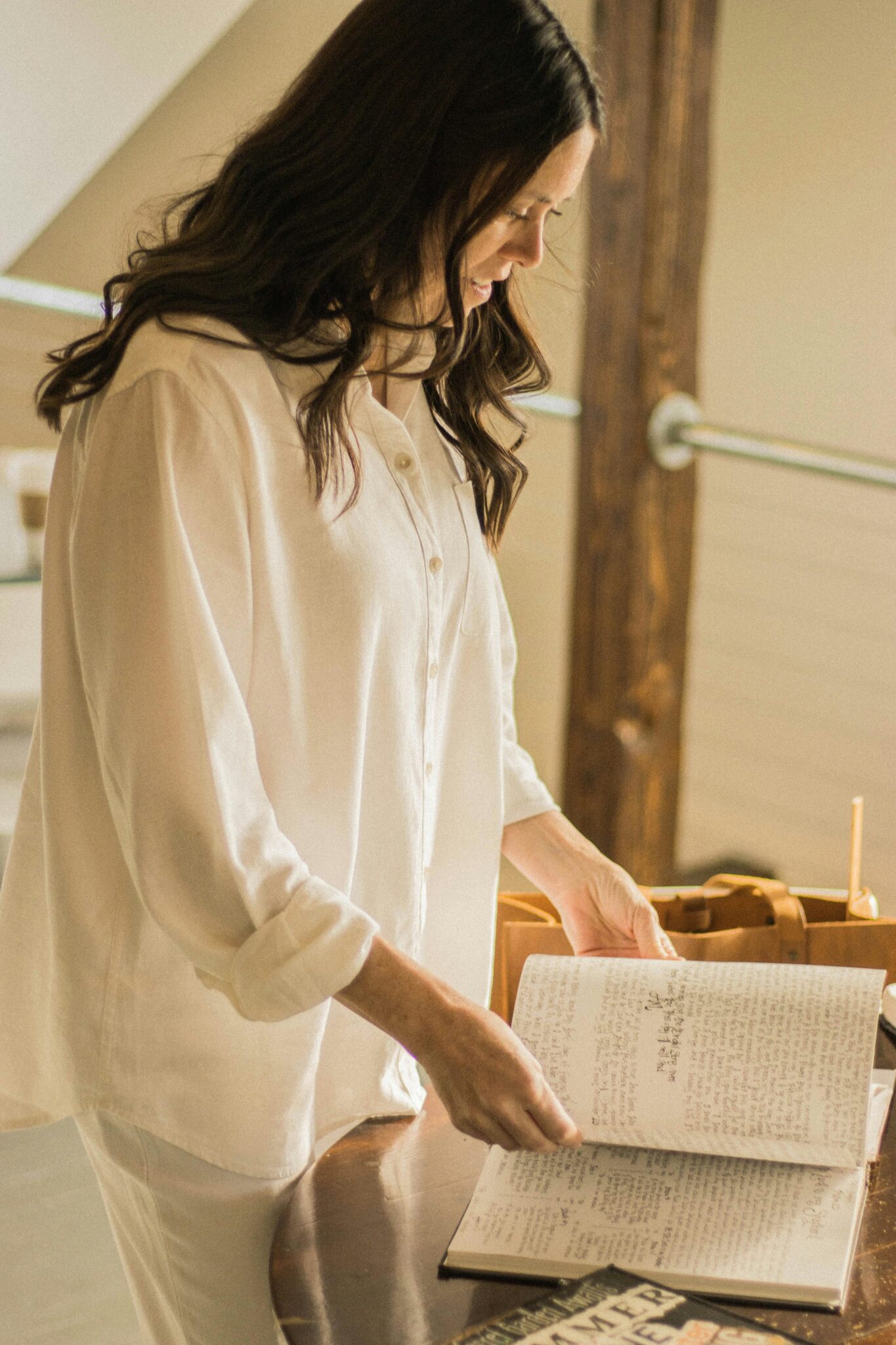 Female artist creating illustrations with a focus on faith and creativity in a sunlit studio.