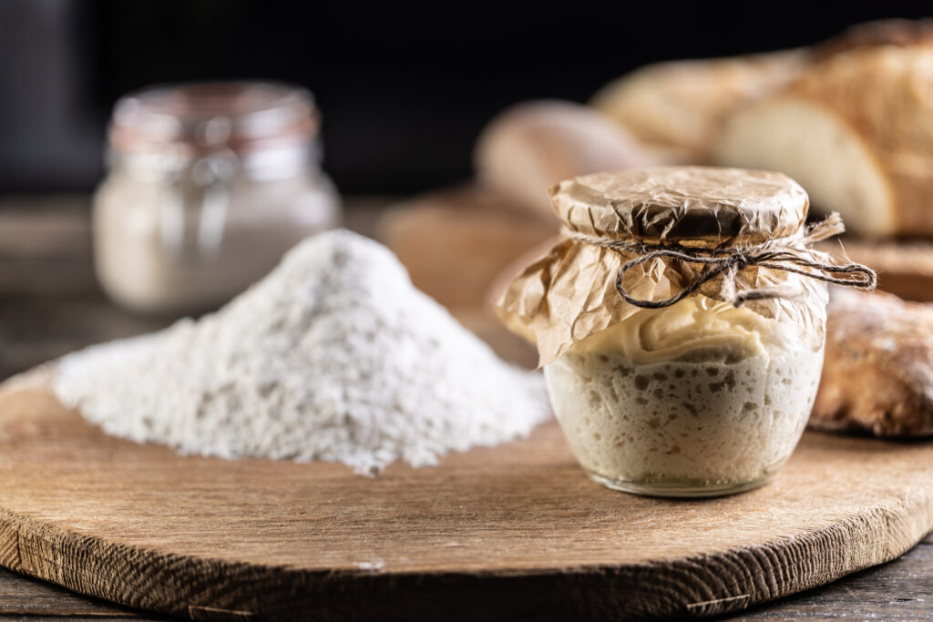 The Sourdough Lesson: Trusting the Unseen rye sourdough ripened in a jar together with flour on a cutting board.